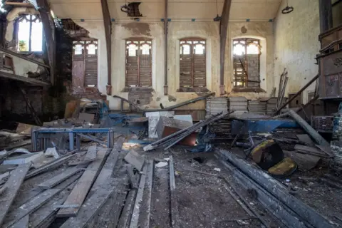 Urbandoned The interior of a church, full of rubble with boarded up windows