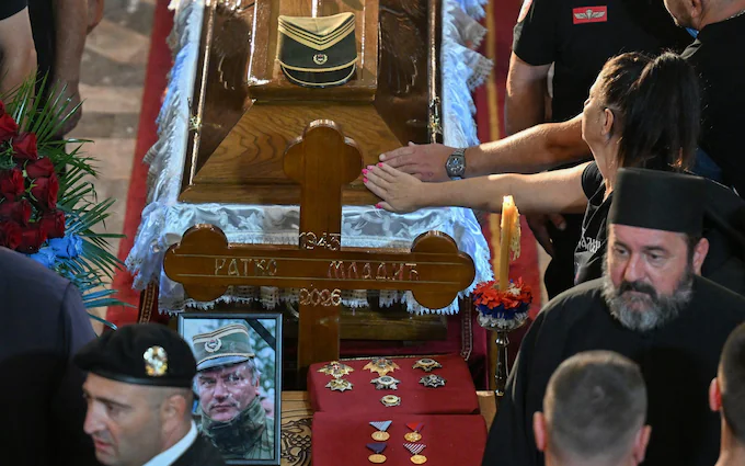 People touch the coffin in St Luka church