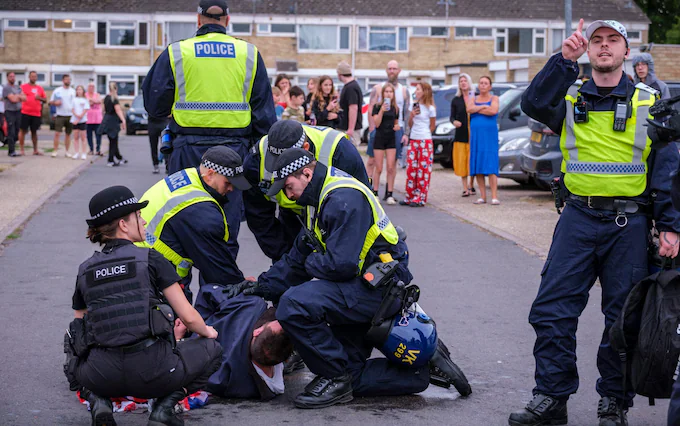 A man is arrested during riots in Thetford